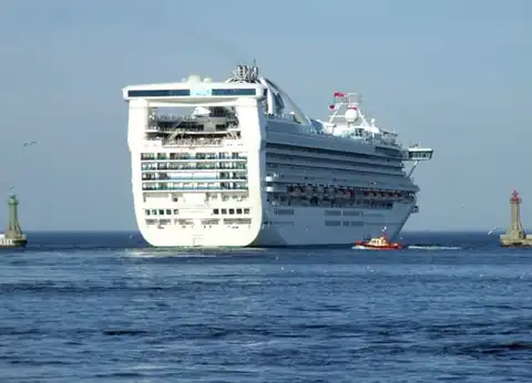 A large cruise ship leaving the port of Gdynia between the breakwater heads