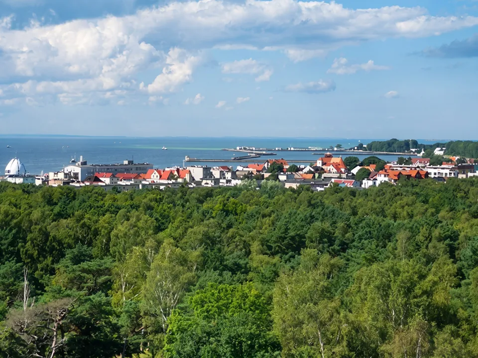 Panorama of Hel – town rooftops above the forest with the sea behind